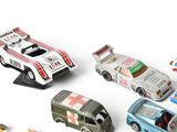 several toy cars are lined up in a row on a white surface
