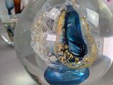 a glass ball with a blue shoe inside of it on a table