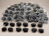 several pairs of sunglasses are wrapped in plastic bags on a table