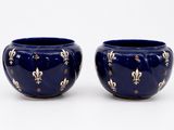 une paire de vases bleus ornés de fleurons dorés sur fond blanc