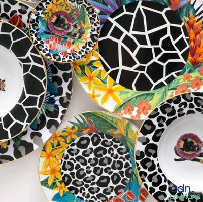 many plates with different designs on them sitting on a table