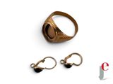 a gold ring with a black stone on it and a pair of earrings