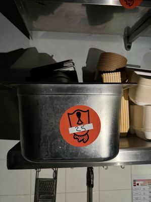 une casserole en métal sur laquelle est collé un autocollant, dans une cuisine
