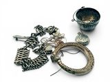 un bracelet en argent et un bol en argent posés sur une surface blanche
