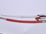 a red and white sword on a white surface