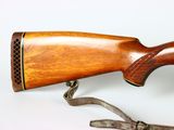 a wooden rifle that is on display on a white surface