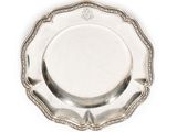 une assiette en argent avec un motif décoratif sur le bord