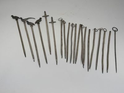 Plusieurs types d'outils métalliques sont disposés sur une surface blanche