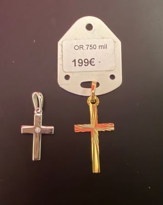 deux breloques en forme de croix posées sur une surface noire