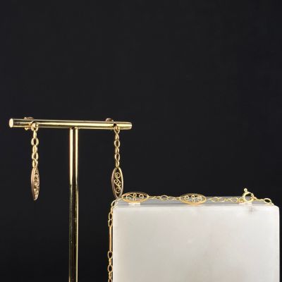 a white and gold purse with a chain hanging from it