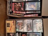 un grand nombre de dvd dans une boîte posée sur le sol
