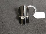 a silver ring with a diamond on it sitting on a table