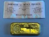 a gold bar and a ticket on a table