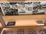 many pairs of glasses on display in a display case