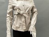 a mannequin wearing a beige jacket and black pants