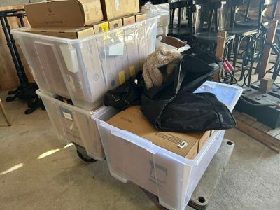 une pile de cartons et un ours en peluche posé sur un chariot