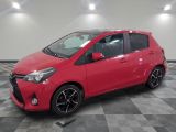 une Toyota Yaris rouge garée sur un sol à damier