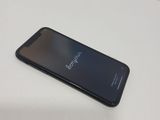 the back of a black phone sitting on top of a white table