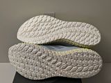 the soles of a pair of white sneakers on a black box
