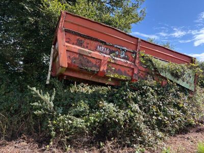 a red dump truck that is sitting in the middle of a field
