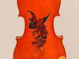 a close up of a violin with a bird painted on the back