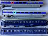 several toy trains are lined up in a row on a white surface