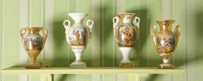 quatre vases posés sur une étagère devant un mur vert
