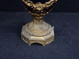 a gold vase on a stand with a blue background