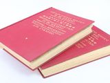 two books sitting on top of each other on a white surface