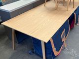 une longue table avec deux chaises posées dessus dans un magasin