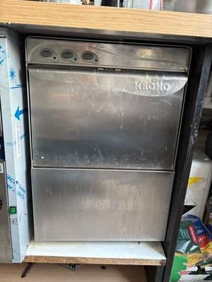 a silver dishwasher sitting on top of a wooden shelf