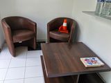 deux chaises et une table basse dans un coin d'une salle d'attente