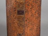 an old book sitting on top of a table next to a gray background