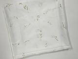 une serviette blanche à motifs posée sur une surface blanche