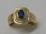 une image d'une bague en or avec un saphir et des diamants
