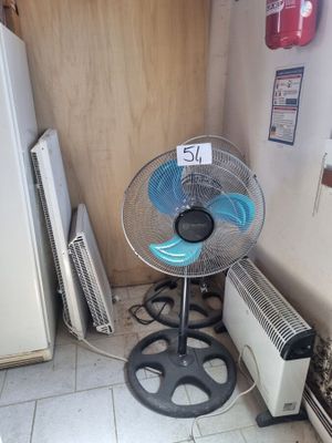 a fan that is sitting on a stool in a room