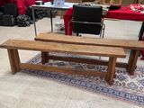 a wooden bench sitting in a room with a rug on the floor