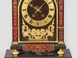 une horloge posée sur une étagère fixée au mur