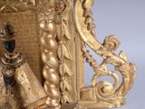a gold clock with a figurine on top of it