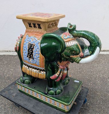 une statue d'éléphant assis sur un socle