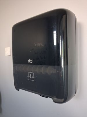 un distributeur de papier essuie-tout noir accroché au mur