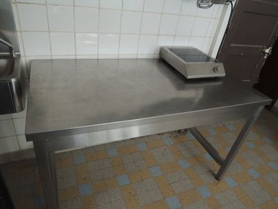 une table en acier inoxydable sur laquelle est posé un grille-pain