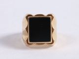 a close up of a gold ring with a black stone in it