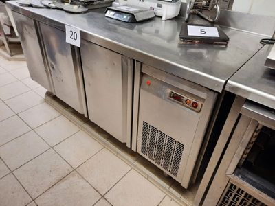 une cuisine avec de nombreux plans de travail en inox
