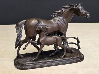 une statue en bronze représentant deux chevaux et un poulain
