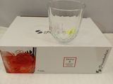 a glass bowl sitting on top of a box on a bed