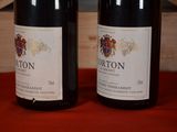 two bottles of wine sitting next to each other on a table