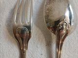 deux cuillères et une fourchette en argent sur une table