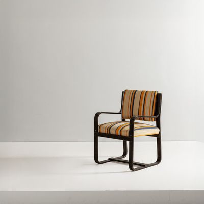 a chair with striped upholstered seat and arm rests on a white surface