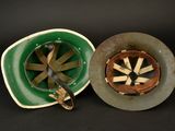 two plates with different designs on them on a black surface